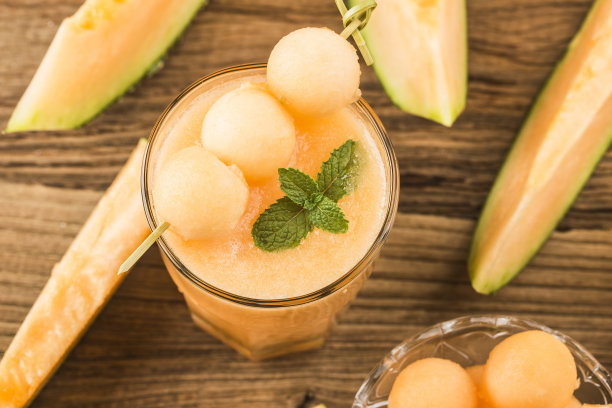 桌上放着一杯薄荷甜瓜汁。哈密瓜图片下载