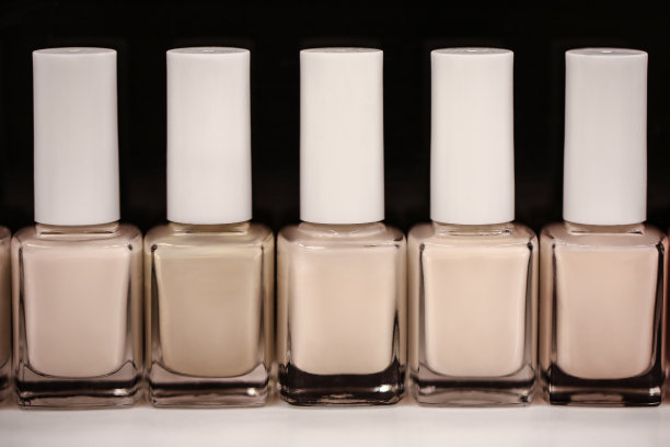 一套瓶子珍珠颜色的指甲油在黑暗的背景图片下载