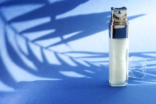 血清瓶，蓝色背景，棕榈阴影。副本的空间。美容、保健的理念图片下载