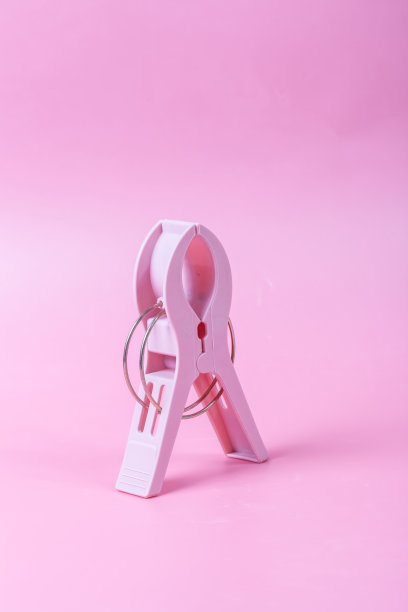 粉红色背景上的大塑料夹子图片下载