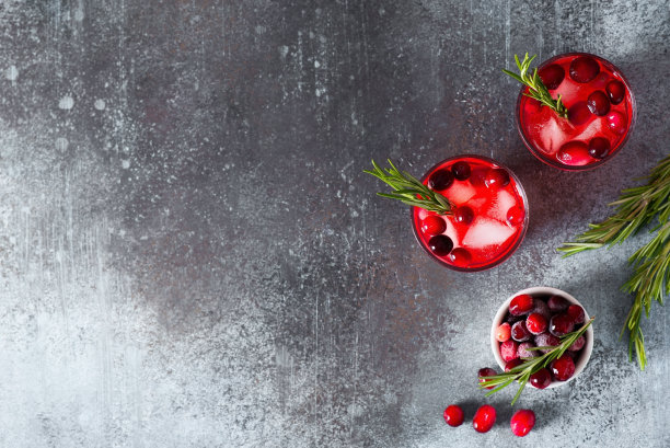 在深色背景上加冰和迷迭香的蔓越莓鸡尾酒图片下载