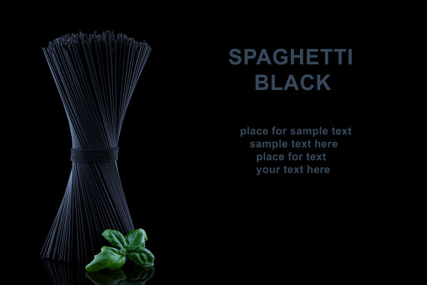 黑色意大利面条与新鲜的绿色巴塞尔叶与黑色背景和文本的地方反射。图片下载