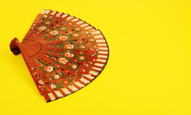 时尚经典西班牙手扇亮黄色背景。图片下载