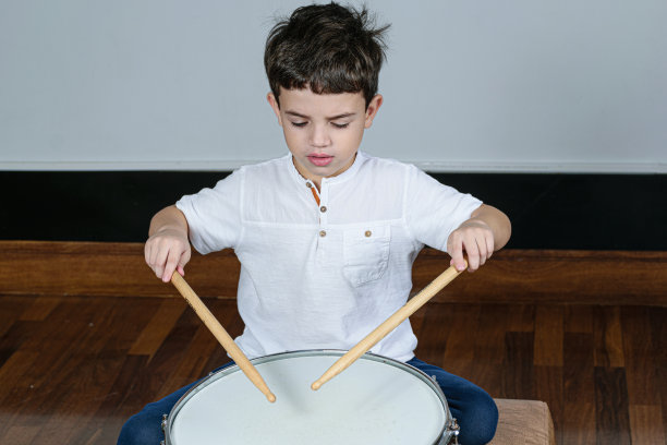 7岁的孩子专注于他的第一堂鼓课。图片下载