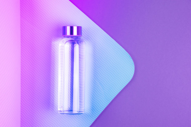 霓虹色的蓝粉色瑜伽垫和紫色背景上的可重复使用的玻璃水瓶。瑜伽普拉提或健身练习。减肥和运动概念。图片下载