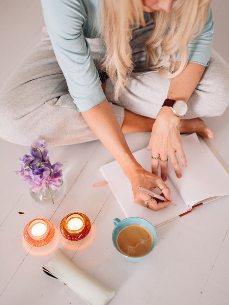 女人计划在舒适的家里用钢笔在笔记本上写作学习图片下载
