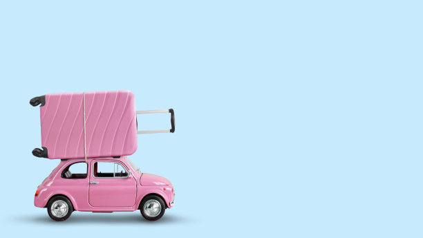 粉红色的玩具车和粉红色的手提箱在一个蓝色的背景屋顶上图片下载