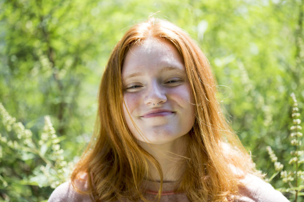 阳光下的红头发自信的微笑肖像户外图片下载