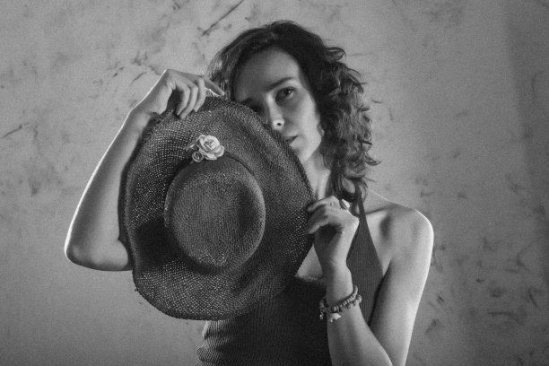 一个手里拿着帽子的年轻女孩的肖像。图片下载