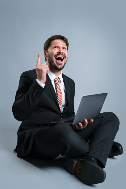 带着笔记本电脑和想法手势的快乐商人图片下载