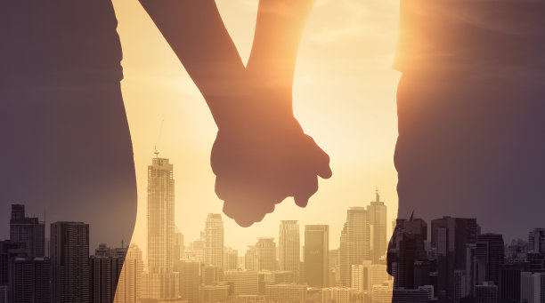 男人和女人手牵着手在城市里。图片下载