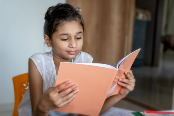亚洲/印度小女孩在家里看书和学习。图片下载