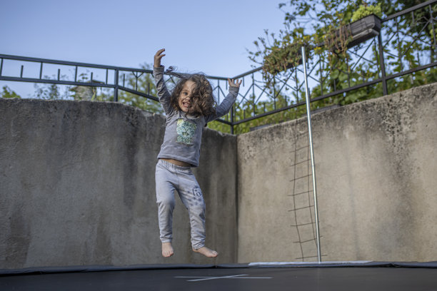 小女孩在蹦床上蹦跳图片下载