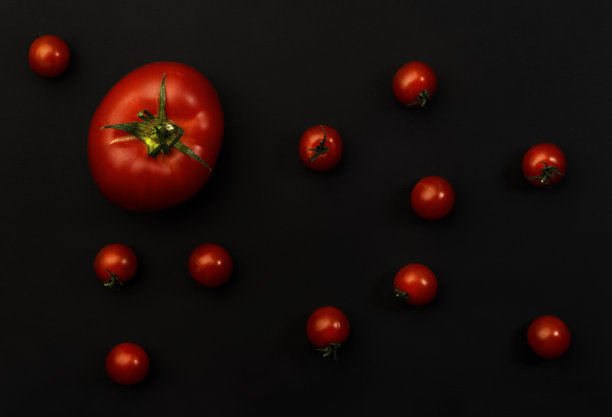 大和樱桃红的西红柿在黑色的背景，俯视图图片下载