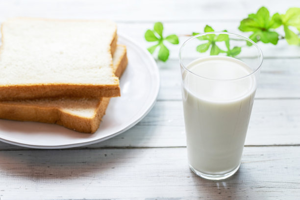 白木板上放着牛奶和面包图片下载