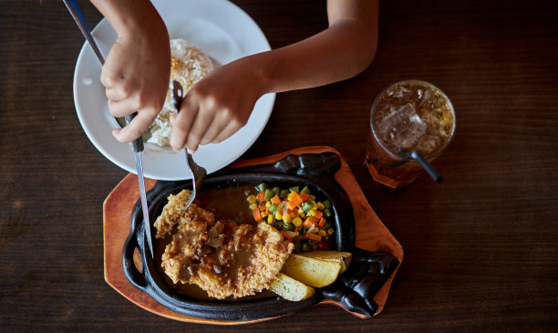 手切鸡酥脆牛排在热板上与烧烤酱，米饭和土豆图片下载