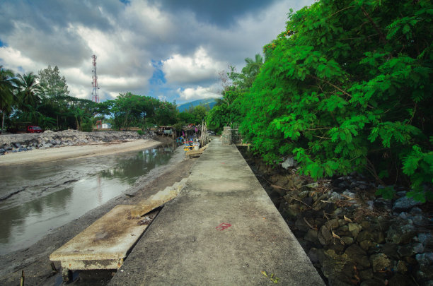 混凝土码头为当地渔民在低潮水对抗多云的天空背景图片下载