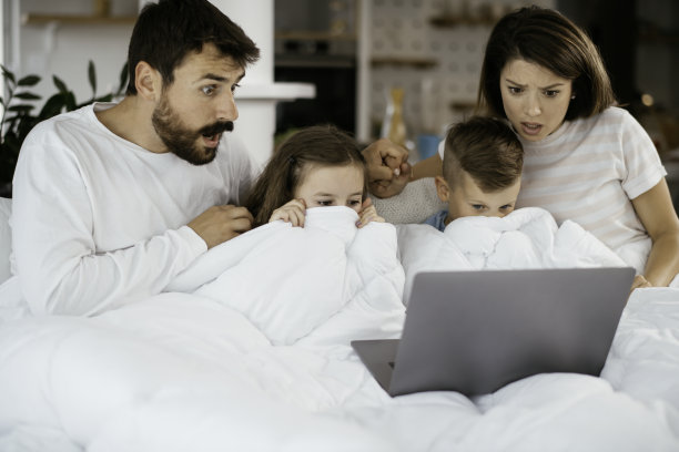 家人在看电影的时候躺在笔记本电脑的床上的照片图片下载