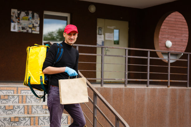 送货，邮件和人的概念-快乐的人送食物在一次性纸袋送客户的家图片下载