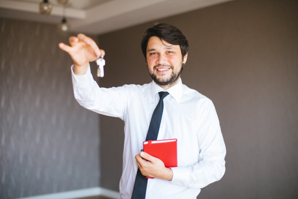 房地产经纪人是房地产经纪人与钥匙在一个白色的背景房地产房公寓的房子图片下载