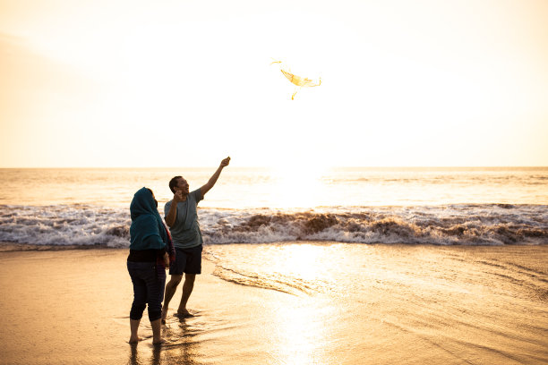 亚洲成年人在海滩上玩风筝图片下载