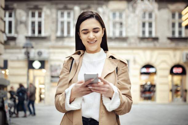 一个快乐的白人女人使用智能手机的正面图片图片下载