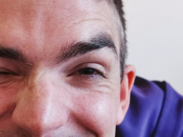 一个厚脸皮微笑的年轻人刚刚发现了一根白色的眉毛图片下载