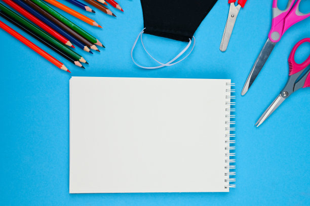 蓝色背景上的笔记本面具和铅笔图片下载
