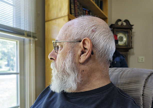 沉思的老人凝视着家客厅的窗户图片下载