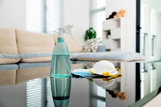 将喷雾瓶和防护口罩放在桌子上图片下载