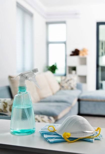 将喷雾瓶和防护口罩放在桌子上图片下载