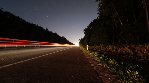 在郊区公路上长时间暴露在阳光下的过往车辆图片下载