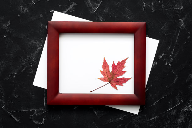 空白纸和木框架装饰枫叶在黑色的石头背景。现代简约邀请模型。俯视图，平放。图片下载