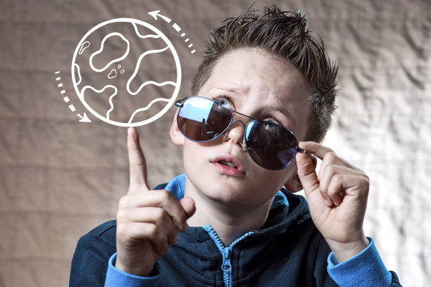 穿着运动夹克的男孩拧着他的手指绘制的地球仪，选择去哪里旅行图片下载