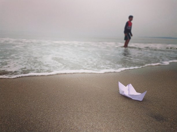 海滩，男人，天空，纸船和水体。图片下载