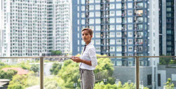 商业女性在建筑屋顶与城市视图使用数字平板电脑库存照片图片下载