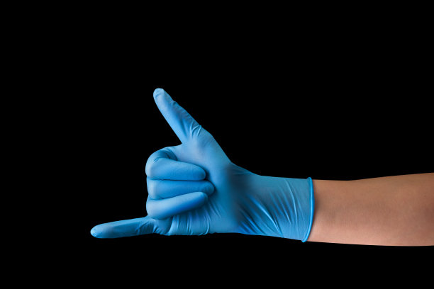 医生的手在医疗手套显示沙卡或冲浪者标志孤立在黑色图片下载
