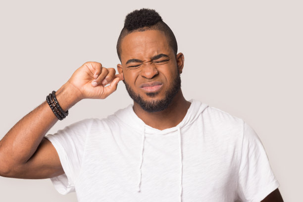 恼怒的黑人塞住耳朵，避免大声的声音图片下载