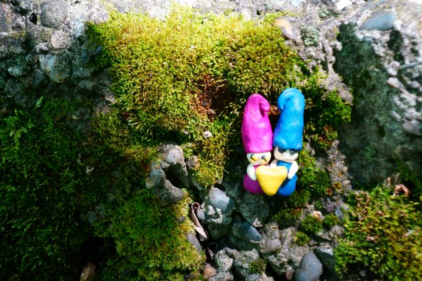 两个相爱的小矮人抱着一颗心。图片下载