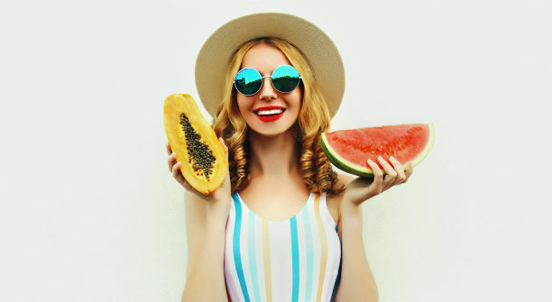 夏天的幸福微笑的女人的肖像水果切片西瓜和木瓜戴草帽，太阳镜在白色的背景图片下载