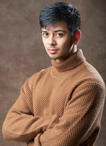 工作室图像的年轻自信的男子摆姿势与双臂交叉图片下载