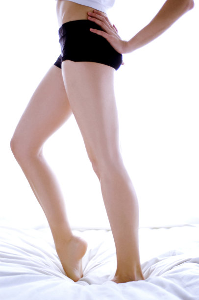 腰部以下的照片，一个女人在黑色内裤踮脚在床上图片下载