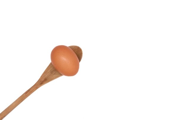 在选择性聚焦中，在白色孤立的背景上，木勺上的一排鸡蛋图片下载
