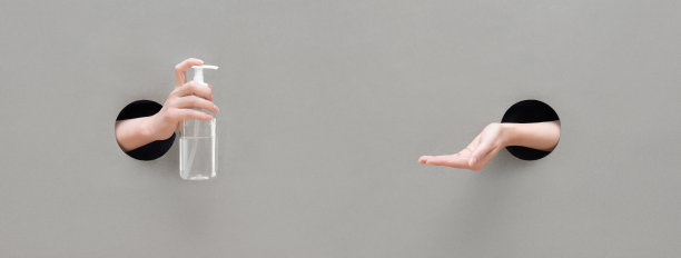 一个女人在灰色的背景上使用消毒液。个人卫生的概念。保护和预防冠状病毒、新冠肺炎。横幅。图片下载