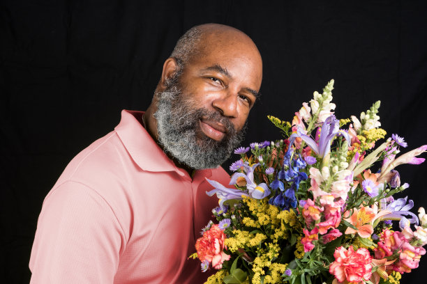 友好的非洲裔美国人与彩色花束在黑色的背景。母亲节或情人节的概念图片下载