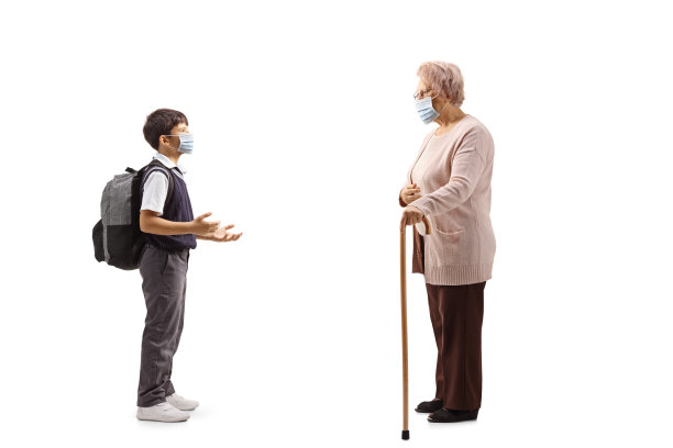 一个戴着防护面罩的男学生与一位年长女士交谈的完整的侧面照片图片下载