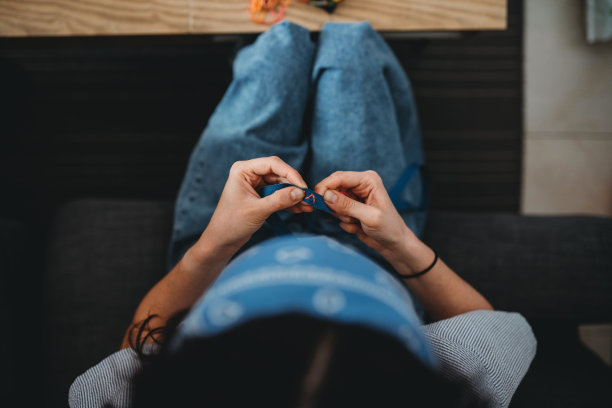 一个年轻女子正在家里缝手镯图片下载