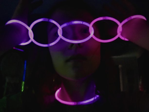 女孩玩环发光手镯。图片下载