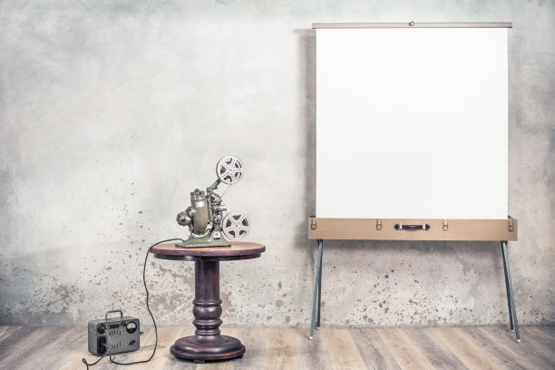 20世纪40年代复古的卷轴电影放映机，老式的电力变压器和便携式电影屏幕。无声电影的概念。复古风格滤镜照片图片下载