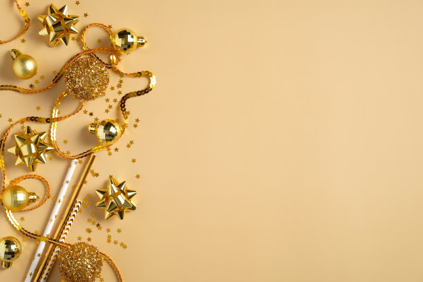 圣诞平铺构图与金色装饰在黄色的背景。圣诞横幅模型，新年明信片模板。顶部视图与复制空间图片下载